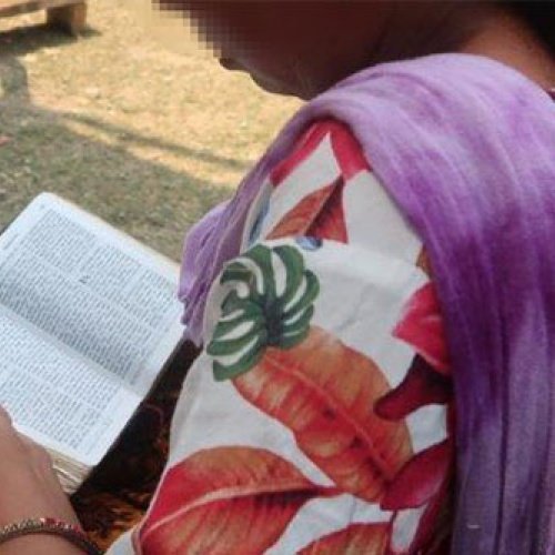 Eine Frau seitlich hält eine Bibel in den Händen
