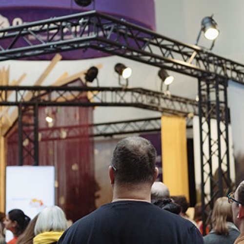 Eine Menschenmenge steht an einem Messestand