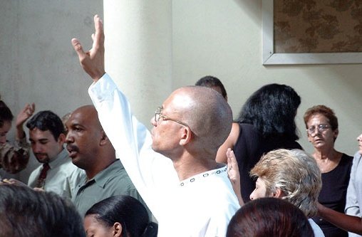 Ein Mann steht inmitten einer Menschenmenge und gebt seinen rechten Arm