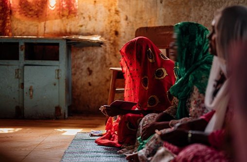 Drei indische Christinnen beten in einem abgedunkeltem Raum
