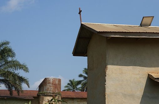 Ein kleines Haus mit einem Kreuz auf dem Dach