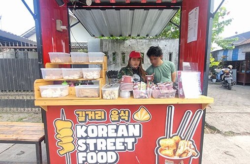 2 Personen stehen an einem Essensstand