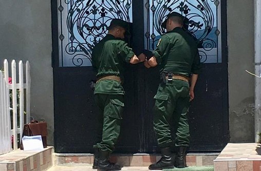 Männer mit grüner Uniform schließen die Tür einer Kirche