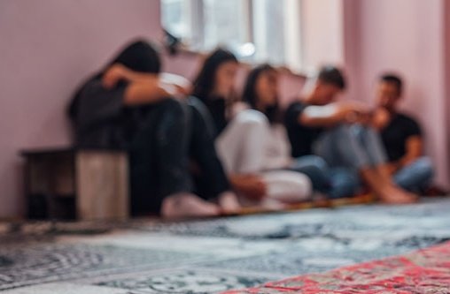 Unscharfes zu sehende Personene die beieinander sitzen