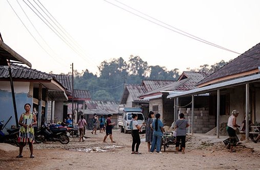 Einige junge Leute stehen auf einer Dorfstraße in Laos