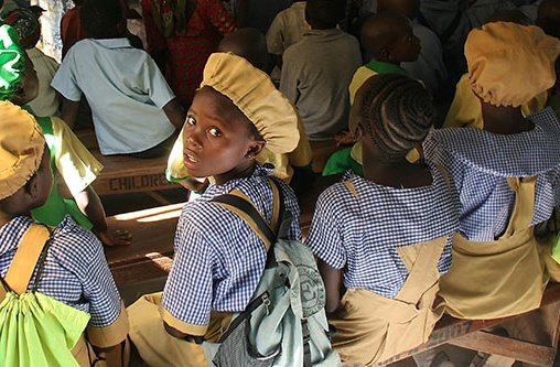 Schülerinnen sitzen auf Schulbänken