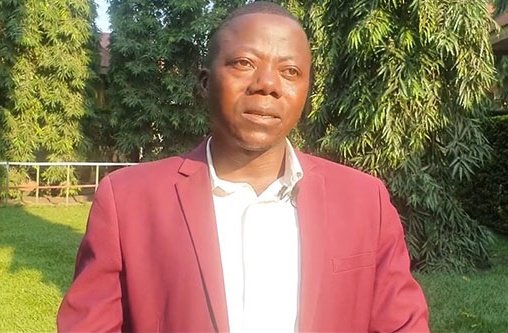 Ein Mann mit Anzug steht vor der Kamera