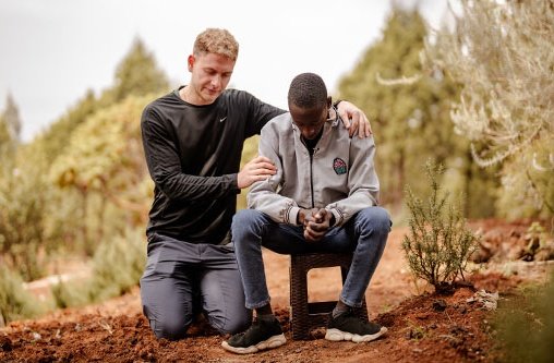 Ein junger Mann betet für einen Christen am Horn von Afrika