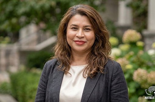 Eine Frau mit braunen Haaren schaut in die Kamera