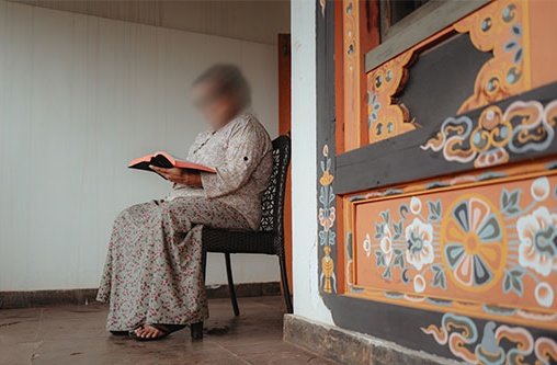 Eine Frau sitzt in einem Raum und liest